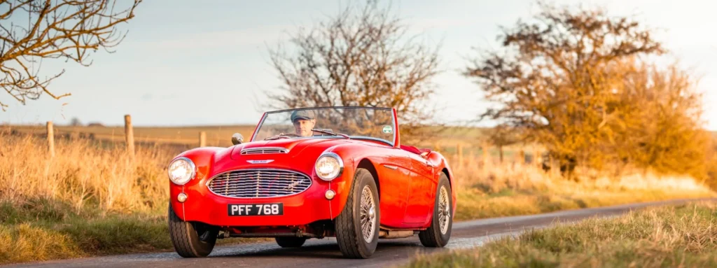 James in his Austin Healey on a great country road enjoying time with the roof down.